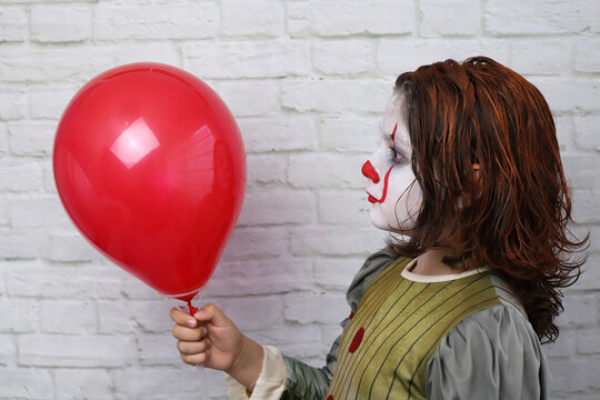 ni&ntilde;o con disfraz de payaso malvado con la cara y el pelo pintados