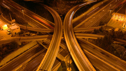 Aerial drone long exposure night photo of urban elevated road junction and interchange overpass in city with light traffic