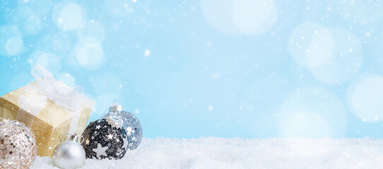 Christmas background with Christmas balls, snow, santa hat and a box with a gift. christmas banner with place for text