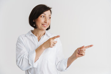 European mature woman smiling and pointing fingers aside