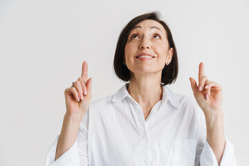 European mature woman smiling and pointing finger upward