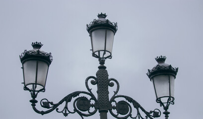 Fototapeta na wymiar Close-up of street lamps in the morning of a cloudy day in the center of Seville.