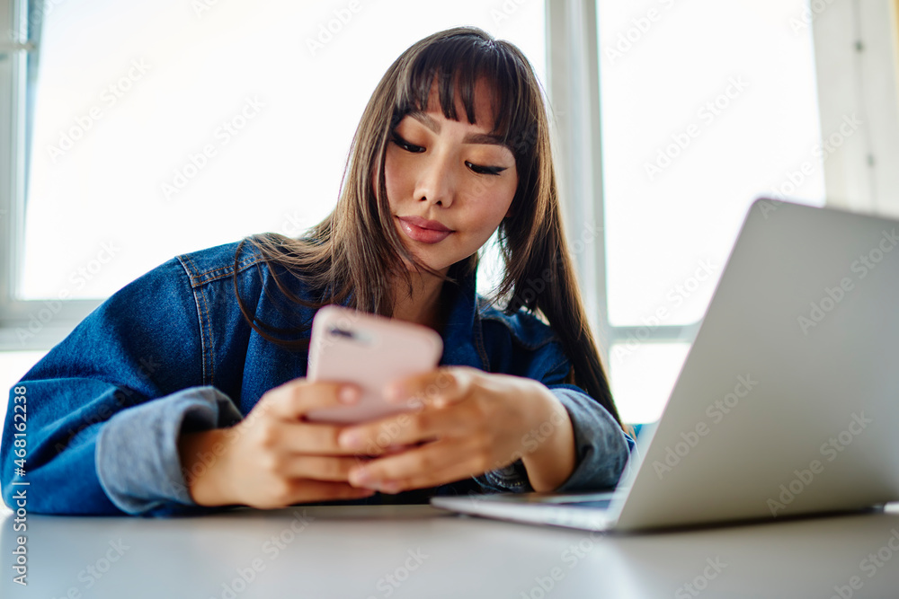 Poster asian female programmer checking mobile notification for making online banking during distance worki