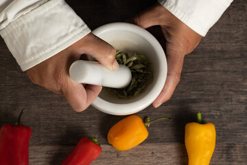 Lady using mortar in kitchen, top view image.