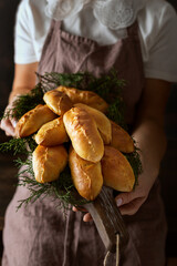 pies with filling on a board in the hands of a girl