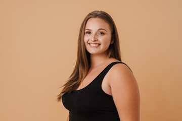 Obraz premium Young woman wearing swimsuit smiling and looking at camera