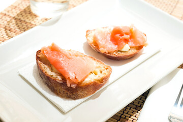 Naklejka na ściany i meble delicious canapes of salted, smoked salmon fillet on slice of fresh ciabatta bread