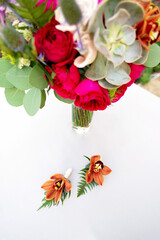 Beautiful boutonnieres of the groom from orchids and dried flowers. Wedding decorations. Floristics. Soft selective focus.