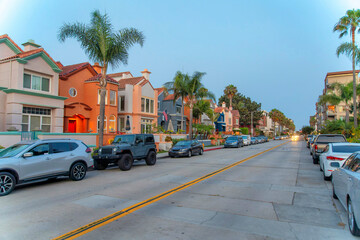 Road in the middle of the residential buildings with parked vehicles at Oceanside, California