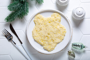Step-by-step preparation of a festive salad with canned fish and vegetables in the shape of a tiger, step 2 - the first layer with potatoes, top view, horizontal