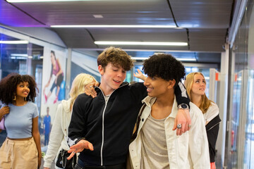 Male and female friends hanging out in shopping mall