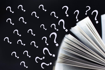 Open book with question marks flying out. Education concept