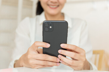 using cell phone hand holding mobile texting message contact us.chatting,search internet information in office.technology device communication connecting