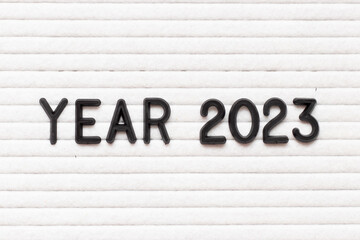 Black color letter in word year 2023 on white felt board background