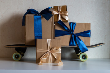 gift boxes with gifts on skateboard on light background © Надежда Сами