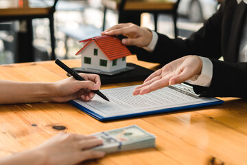 Customers interested in buying a home sign a signature to enter into a home purchase contract with...