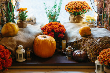 autumn decor in the shop window, yellow leaves and pumpkin