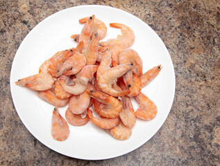 Red frozen shrimps on a white plate.