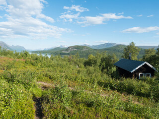 Mountain lodge on the shore of lake Lulealven, Lule river dam in Saltoluokta in birch forest in...