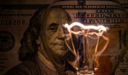 Rising electricity prices. Old light bulb and dollar bills