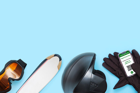Gloves, Goggles, Ski, Helmet For Skiing And Smartphone With Digital Green Pass And Qr Code On The Screen Lays On Ski. Health Passport Or Certificate Of Immunity. Tourism Without Restrictions.