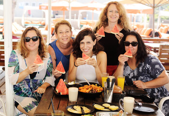 Women best friends sitting in summer cafe on the beach