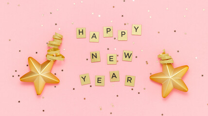 Happy New Year text made from golden letters with golden toy stars and glitter