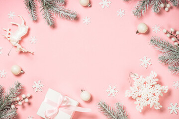 Christmas flat lay background at pink. Fir tree, present box and white christmas decorations. Top...