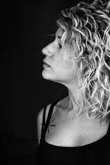 Profile black and white portrait of a beautiful young woman with blonde and curly hair