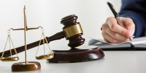 Lawyer working with contract papers and wooden gavel on tabel in courtroom. justice and law...