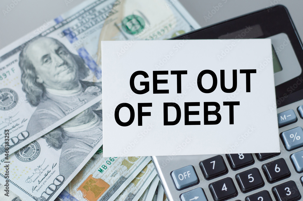 Poster on the table money and a calculator and a card with the words get out of debt on it. business concep