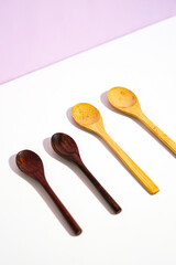 set of two wooden spoons in dark and two wooden spoons in light. a studio shot of the organic utensils. suitable for advertisement.