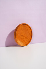 a standing wooden placemat on the lavender wall. a studio shot of the organic utensils. suitable for advertisement.