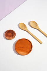 the wooden utensils consist of a smaller and a bigger placemat with two spoons. a studio shot of the organic utensils. suitable for advertisement.