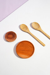 the wooden utensils consist of a smaller and a bigger placemat with two spoons. a studio shot of...