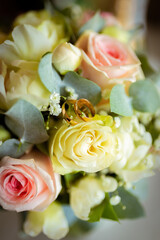 Wedding rings on a petal of a rose. Concept for a wedding card. The bride's bouquet. High quality photo