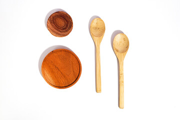 the wooden utensils consist of a smaller and a bigger placemat with two spoons. a flat lay shot of...