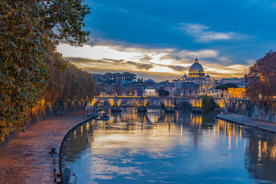 Twilight beacons on the Ponte Umberto I bridge overlooking St. Peter's Cathedral and Vatican city. 
