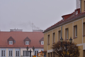 The smoke from the chimney of a coal stove in an old building on a gloomy autumn day. Cold.