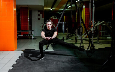 Obraz premium guy doing exercises on TRX loops in the gym