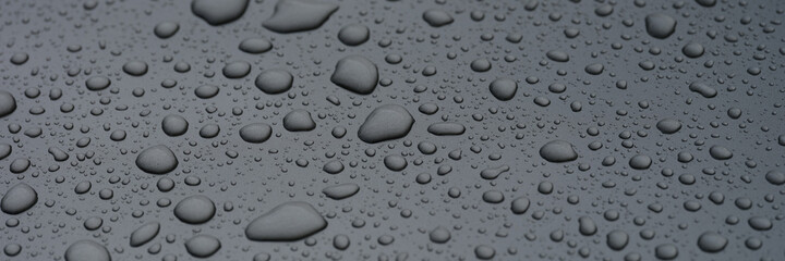 Raindrops on glass against background of dark sky closeup