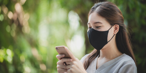 Woman wearing face mask using smartphone