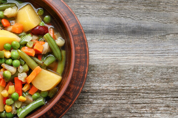 Bowl of delicious turnip soup on wooden table, top view. Space for text