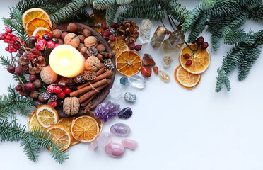 Crystal gemstones, natural winter decor, candle on white table. energy healing minerals for Witchcraft Ritual. Esoteric, relax, life balance concept. Christmas, Magical Winter Solstice. flat lay