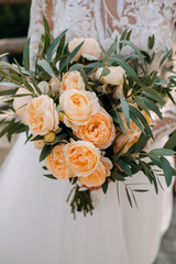 Closeup of a bridal bouquet of pale orange roses.