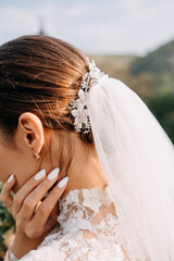 Closeup of a simple bridal hairstyle with a comb and veil.