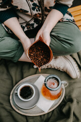 Closeup of a woman holding an opened pack of coffee beans.