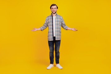 Photo of young happy man hold hands palm demonstrate offer product advert promo isolated over yellow color background