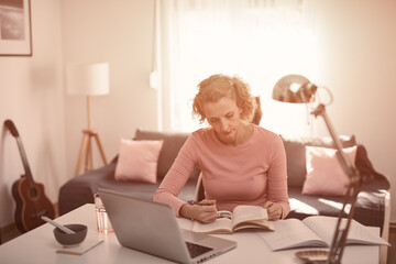 Woman in 40s working from living room at home.