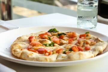 Alfredo pizza with tomato and oregano in an elegant restaurant